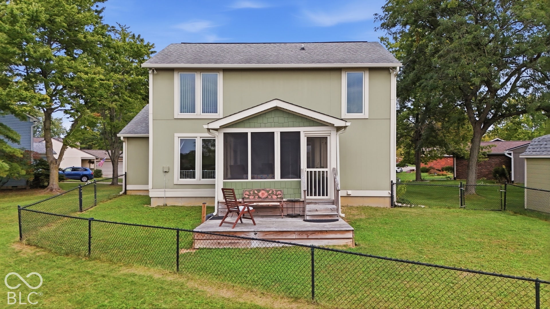 Two-story residence featuring a fenced backyard, exterior screened porch, and shingle-style siding accents