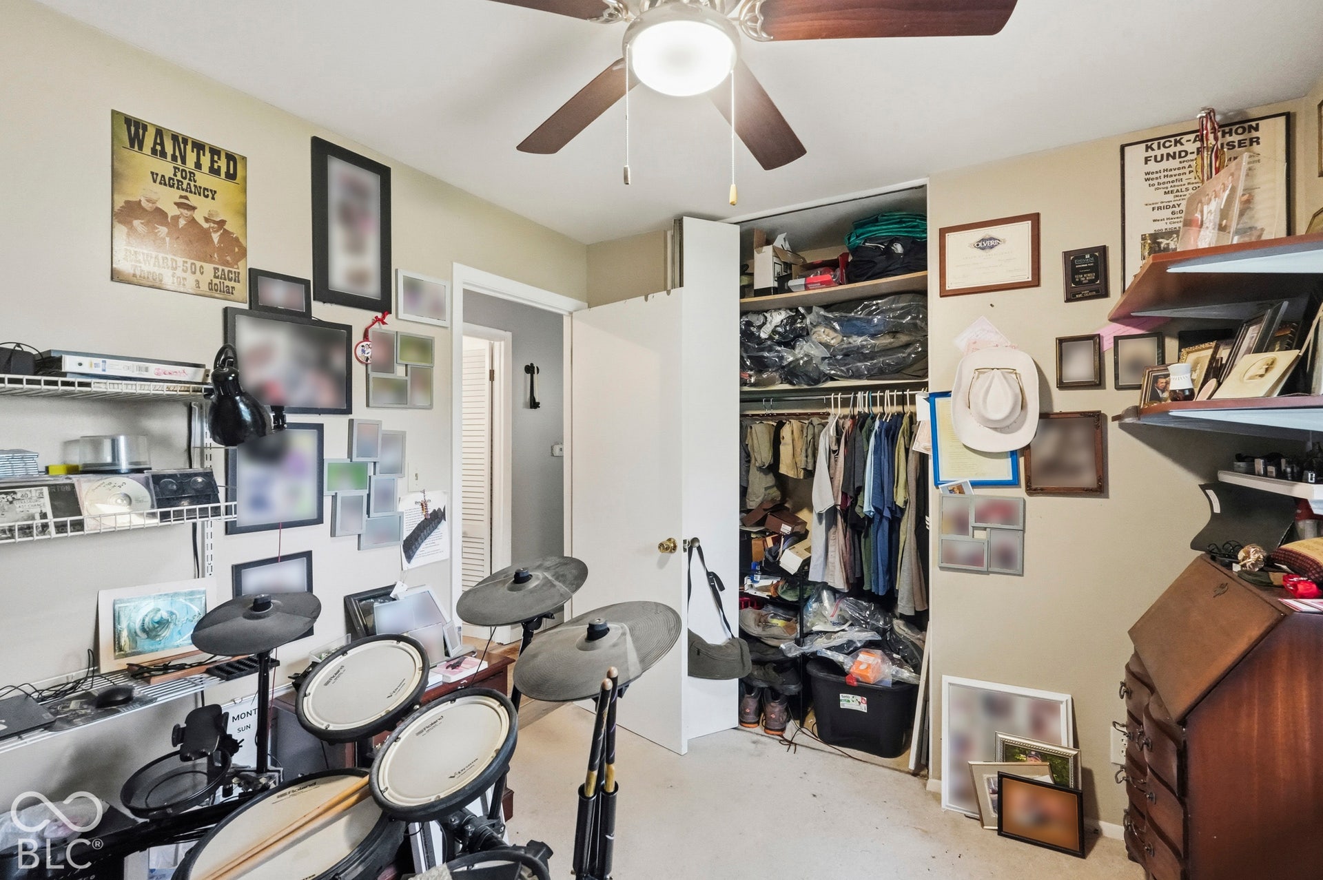 In this bedroom features a ceiling fan with integrated lighting, wall-mounted wire shelving, and a built-in closet with sliding doors.