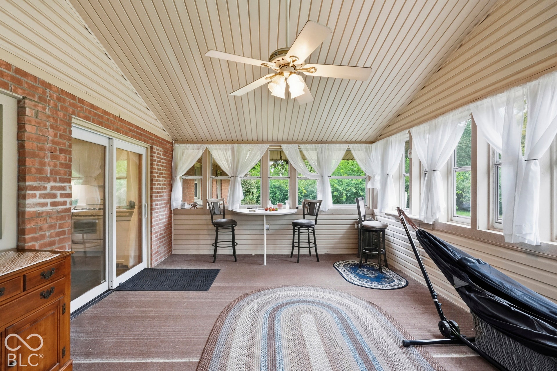 This view of the sun room shows the sliding glass door that leads into the kitchen. Notice all of the windows inviting the sunshine.