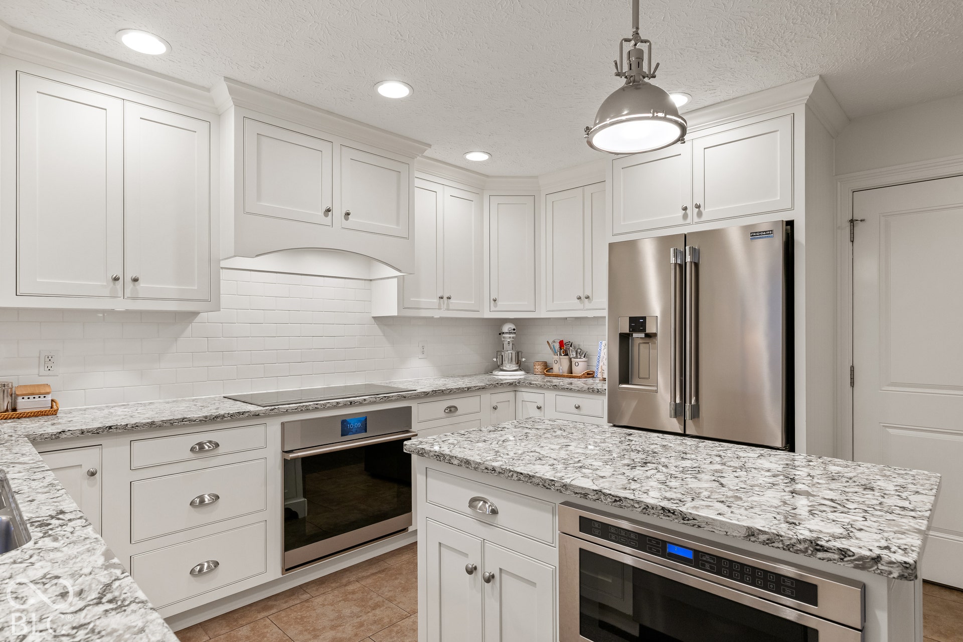 Kitchen featuring white shaker-style cabinetry, stone countertops, stainless steel appliances, a tiled backsplash, and recessed lighting