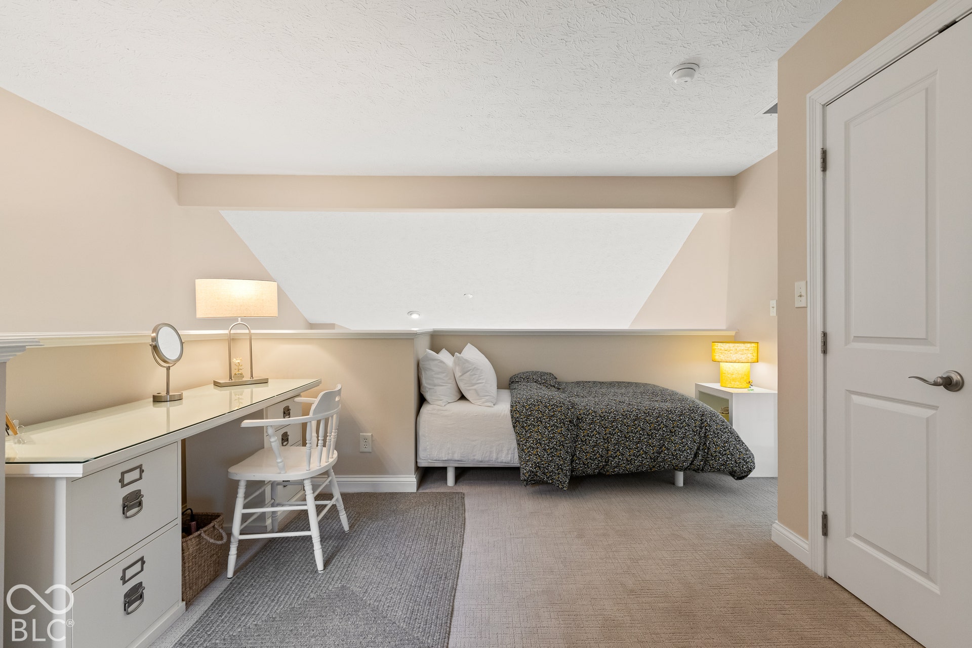Neutral-toned bedroom featuring vaulted ceiling lines, built-in cabinetry, and wall-to-wall carpeting