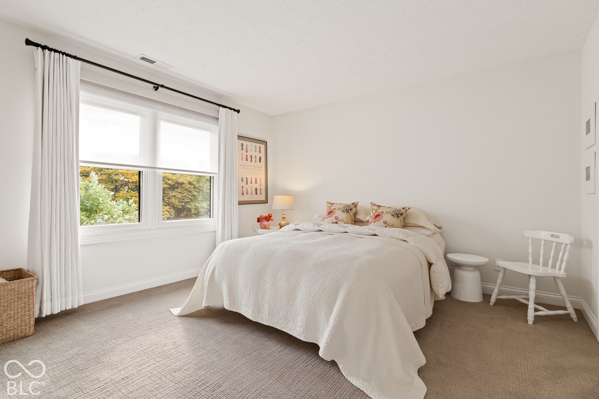 Neutral-toned carpeting, dual-pane window with black rod hardware, and textured walls