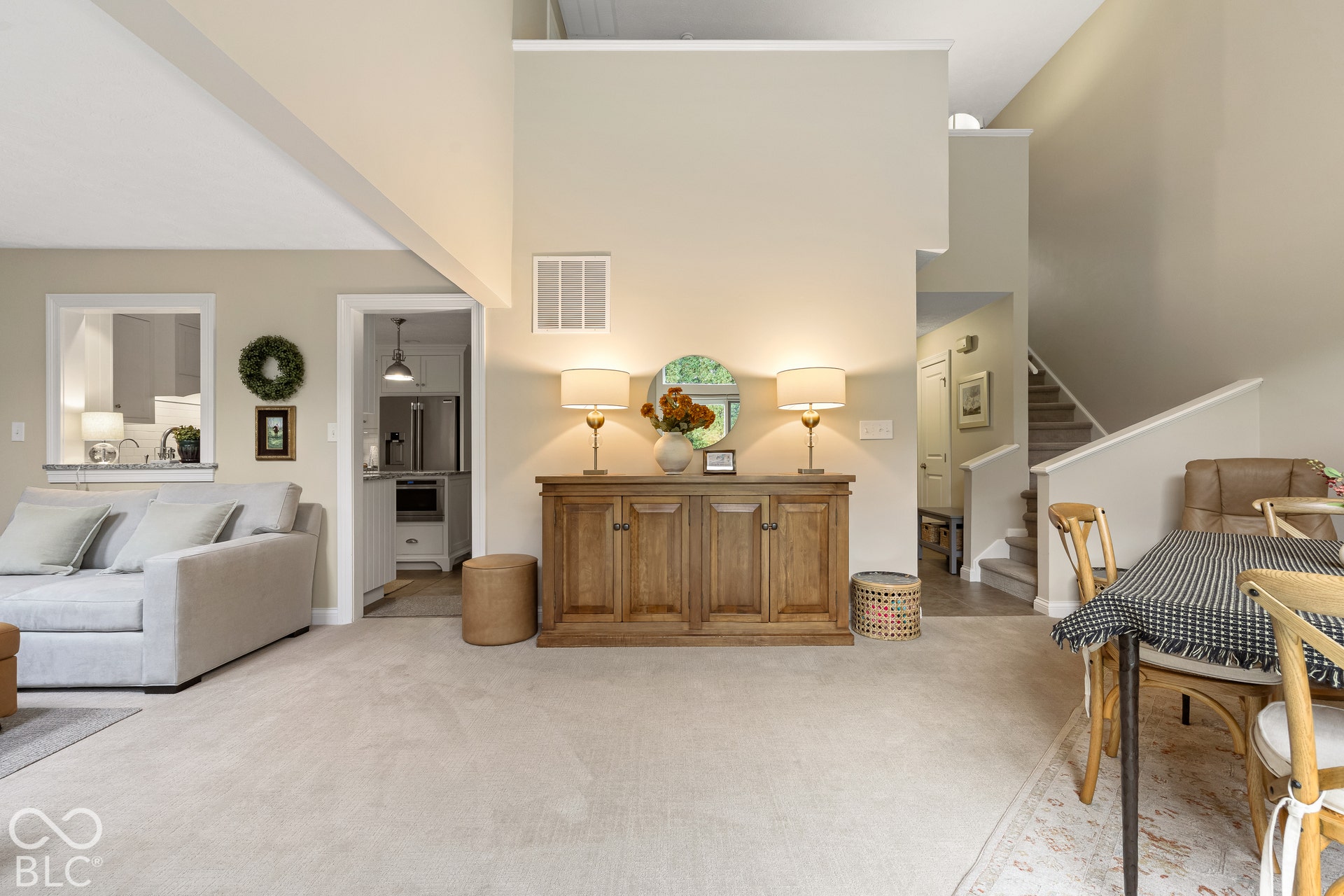 High-ceiling architecture featuring a split-level design with a carpeted staircase and neutral wall finishes