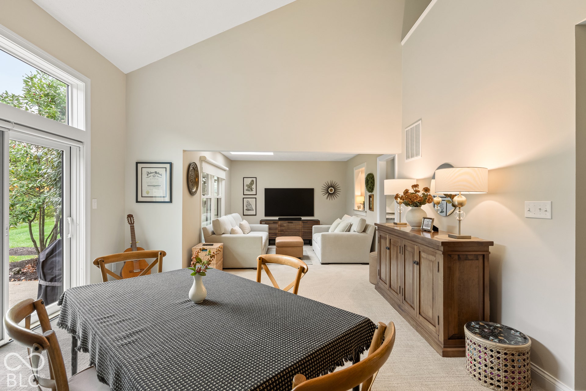 Vaulted ceiling, sliding glass doors, neutral interior paint, and carpeting