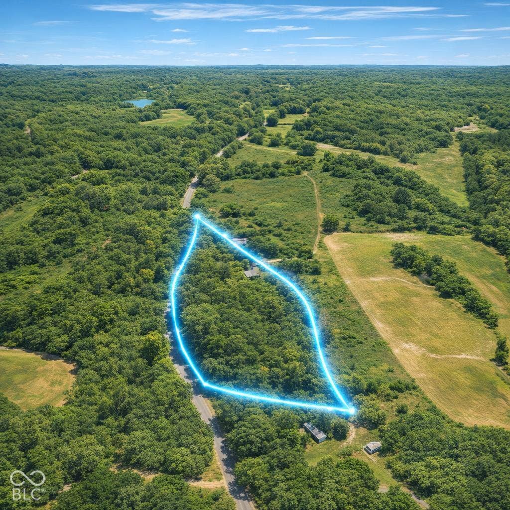 Expansive acreage featuring mature woodlands and a paved road frontage