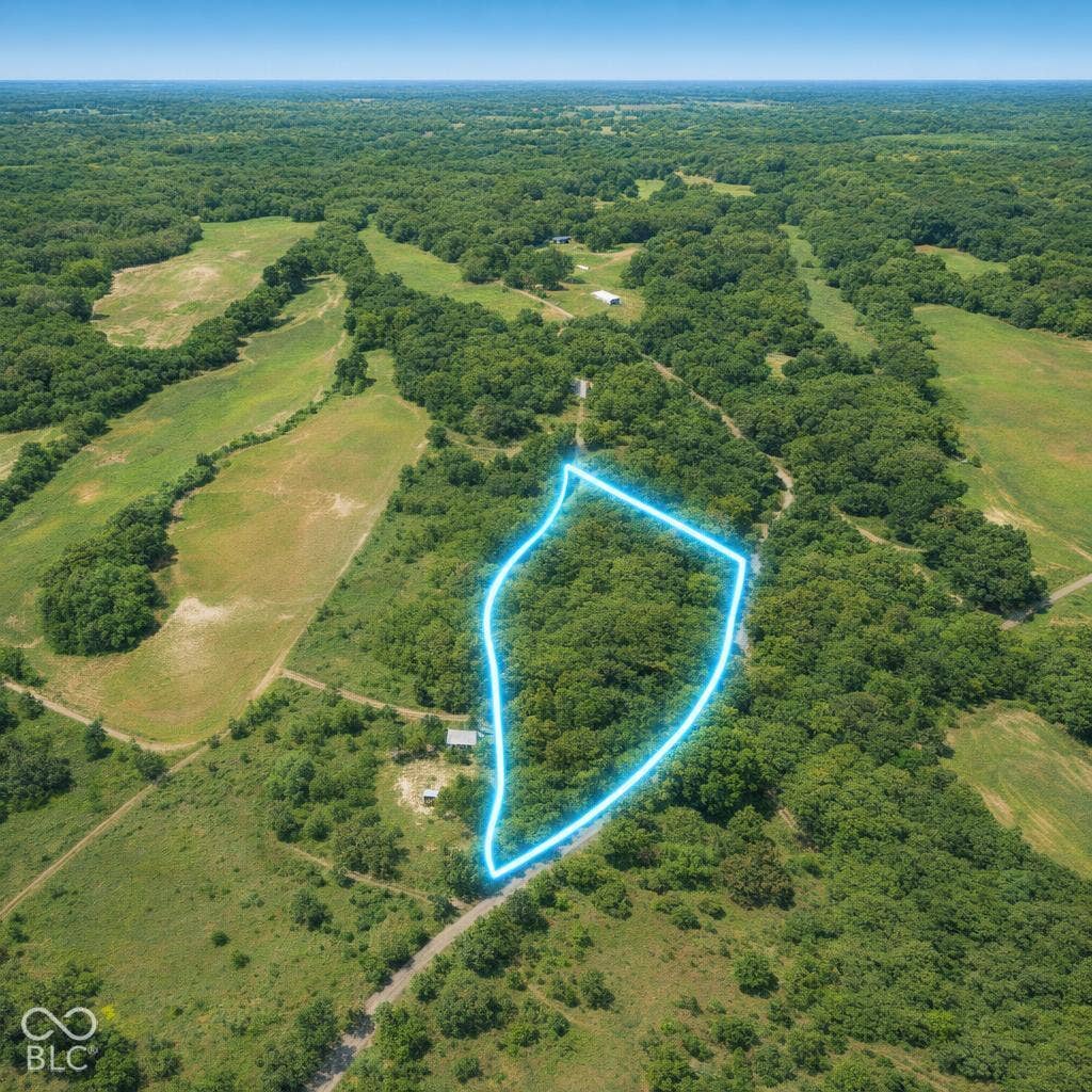 Expansive parcel featuring mature trees, diverse terrain, and road access