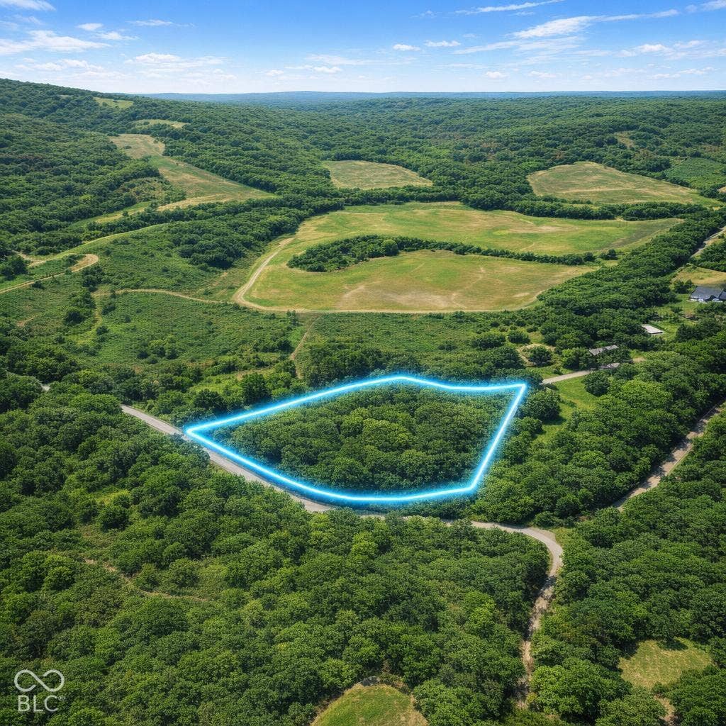 Expansive parcel of land featuring mature trees, rolling topography, and direct road access