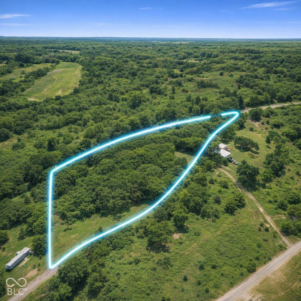 Expansive acreage featuring mature trees, rolling grassy terrain, and direct access to an unpaved road