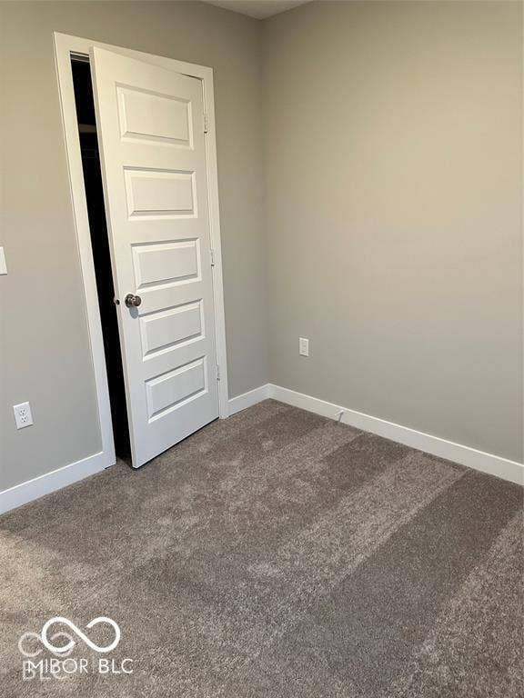 Neutral interior featuring wall-to-wall carpeting and a solid-core, five-panel interior door