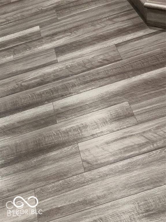 Grey-toned wood-finish flooring featuring a detailed grain pattern and planks with staggered seams