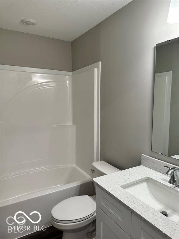 Full-height tub and shower surround, white shaker-style vanity cabinet, neutral stone-composite countertop, undermount sink with chrome fixture, and polished rectangular wall mirror