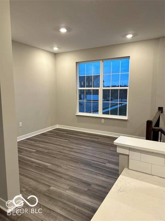 Room featuring wood-finish flooring, recessed lighting, and a multi-pane window with white trim