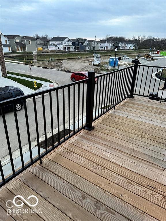 Elevated wooden deck featuring black metal railings