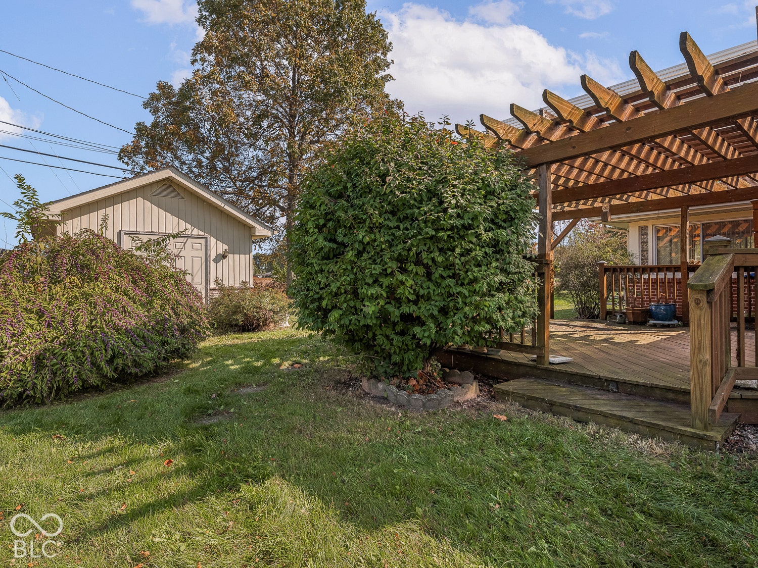 Wood-framed pergola, multi-level wood decking, and 13' x 17' detached storage structure with electricity