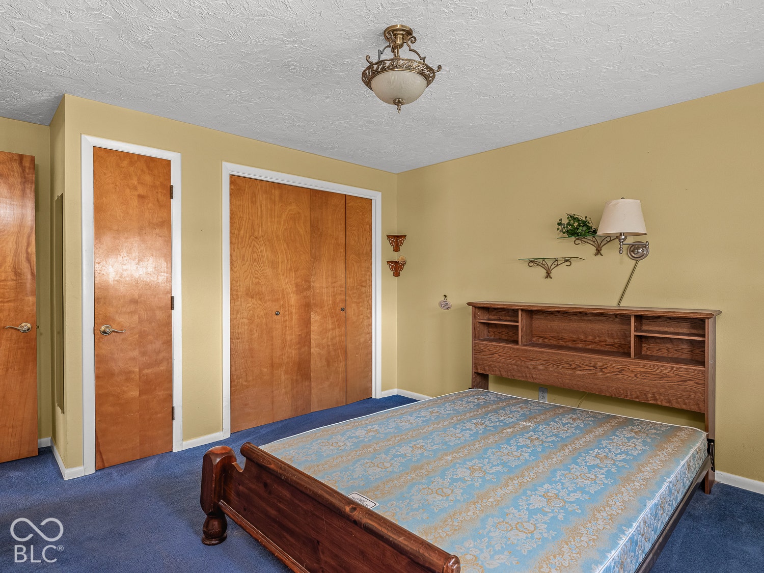 Room featuring ceiling lighting, wood doors, and an en suite bathroom.