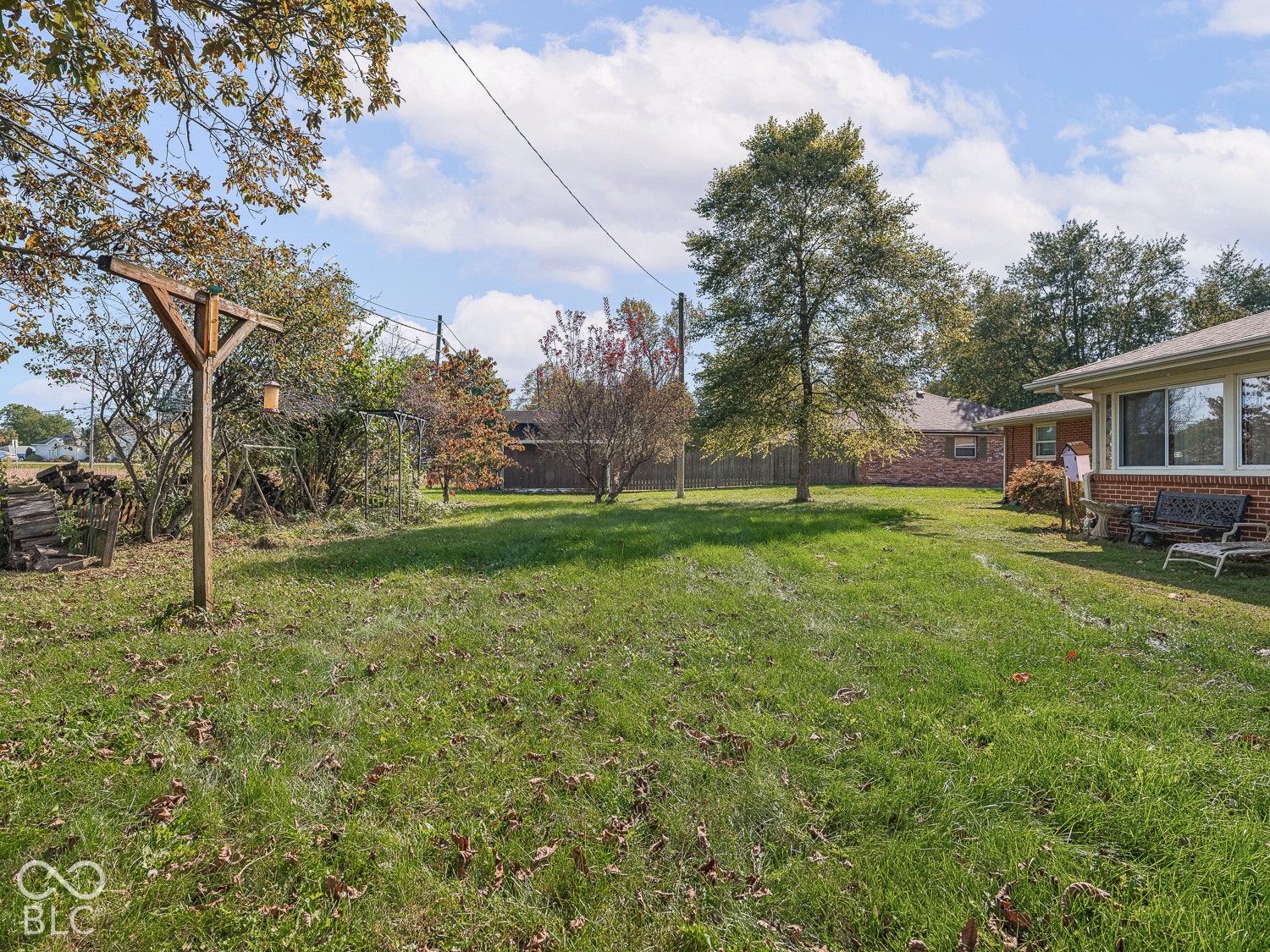 Expansive backyard featuring a brick exterior facade, and mature trees