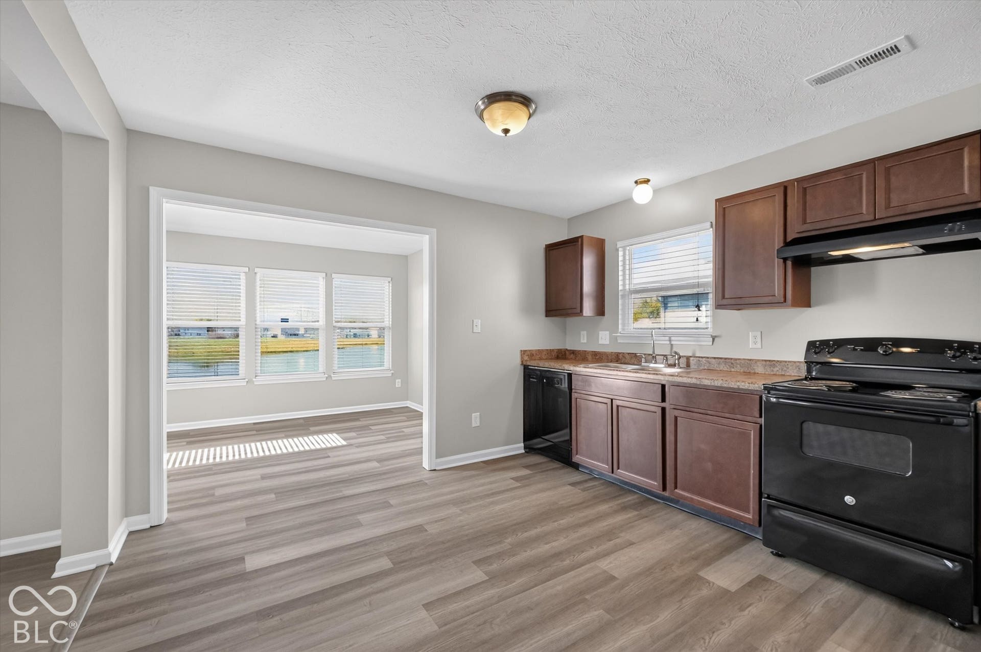 Kitchen featuring newer LVP flooring and black appliances
