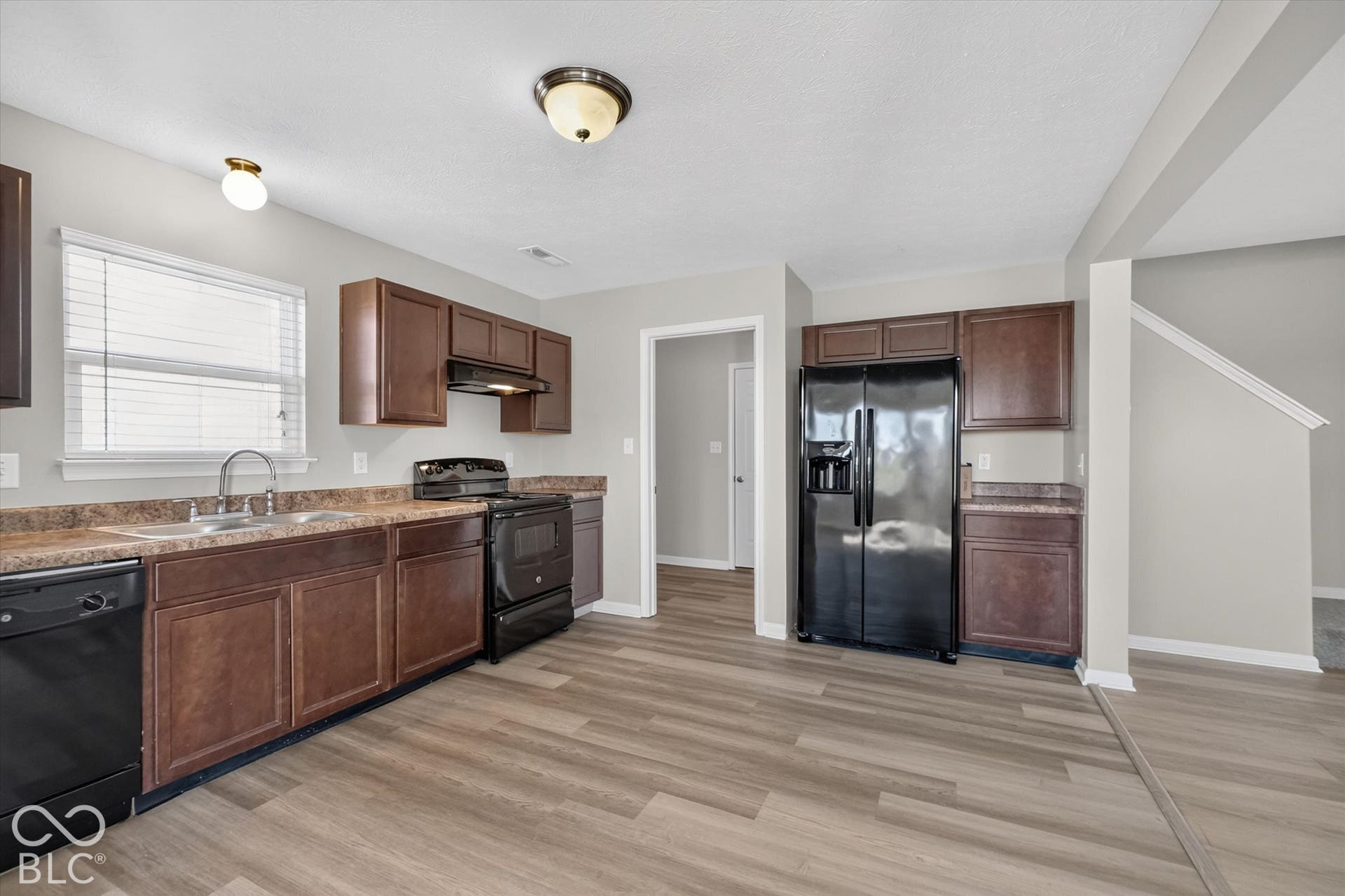 Kitchen featuring newer LVP flooring and black appliances