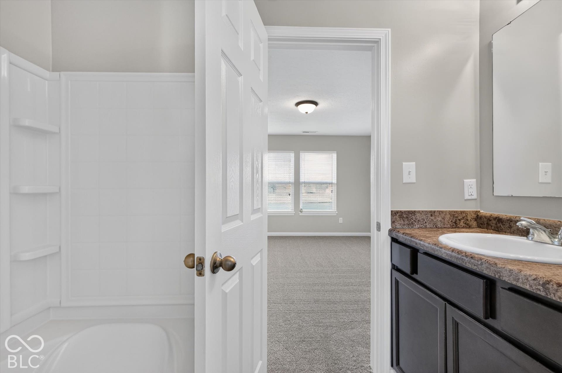 Primary bathroom featuring a vanity and shower/bathtub combination