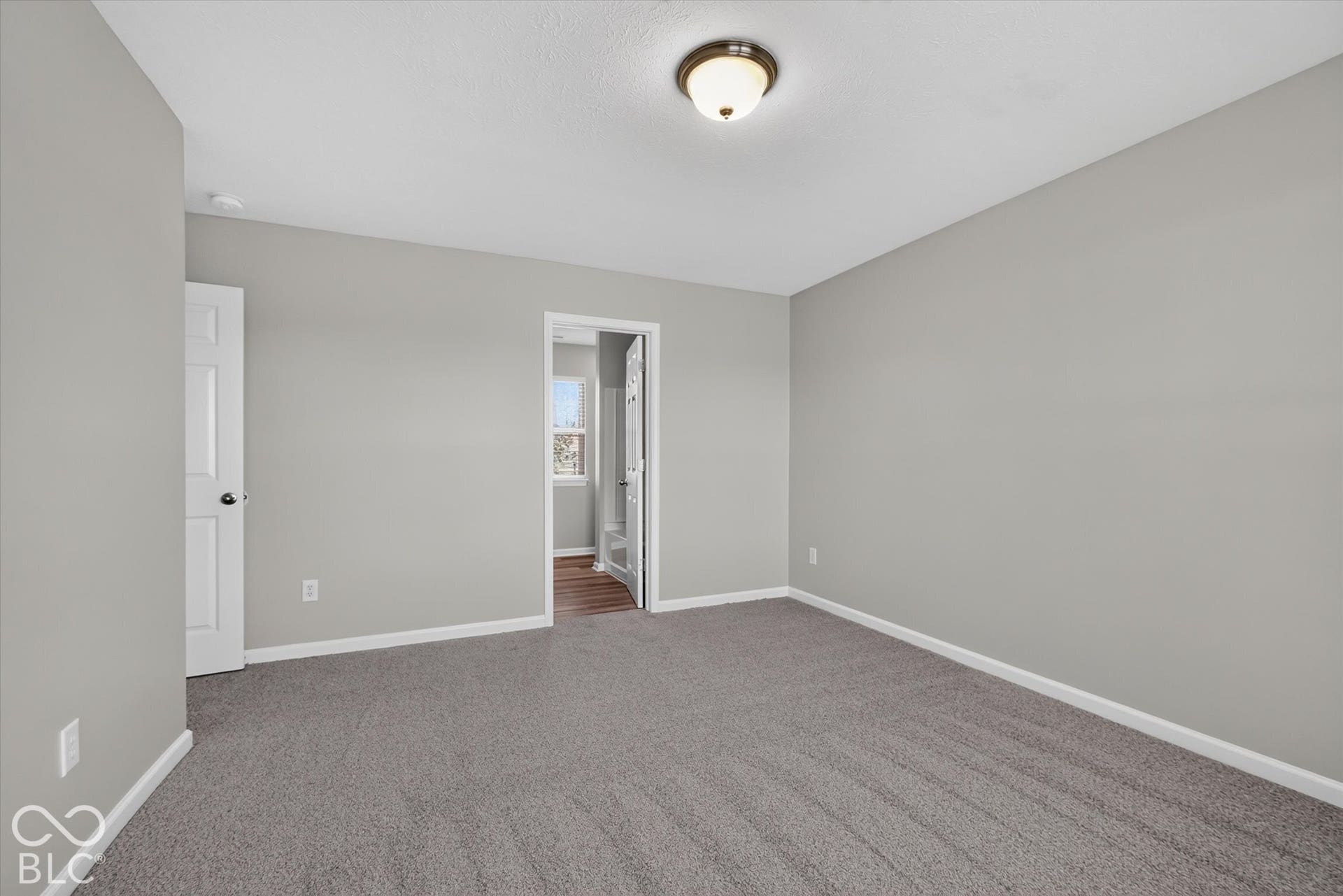 Spacious primary bedroom with new carpet and neutral wall color