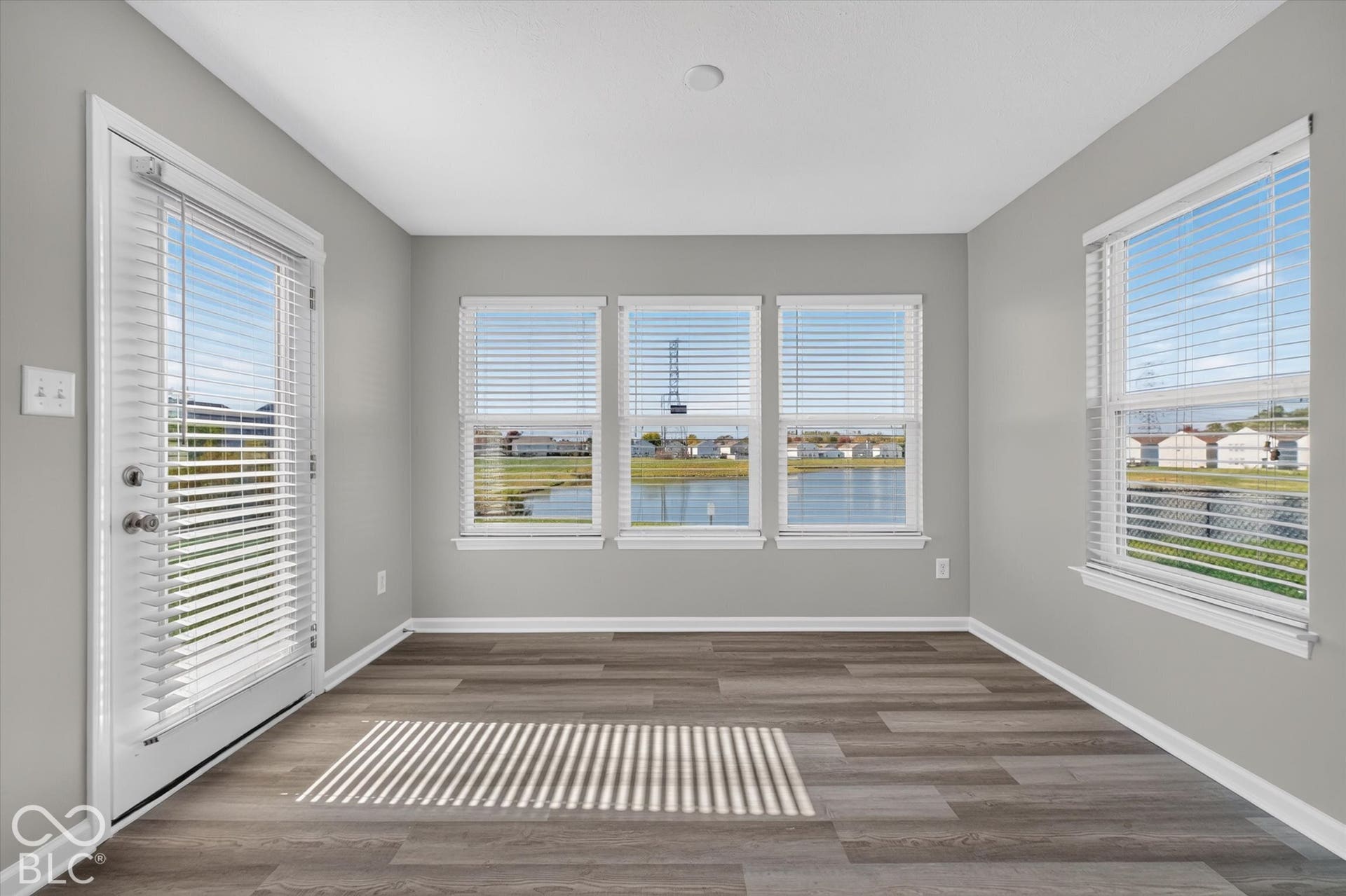 Versatile sun room with newer LVP flooring and abundant natural light