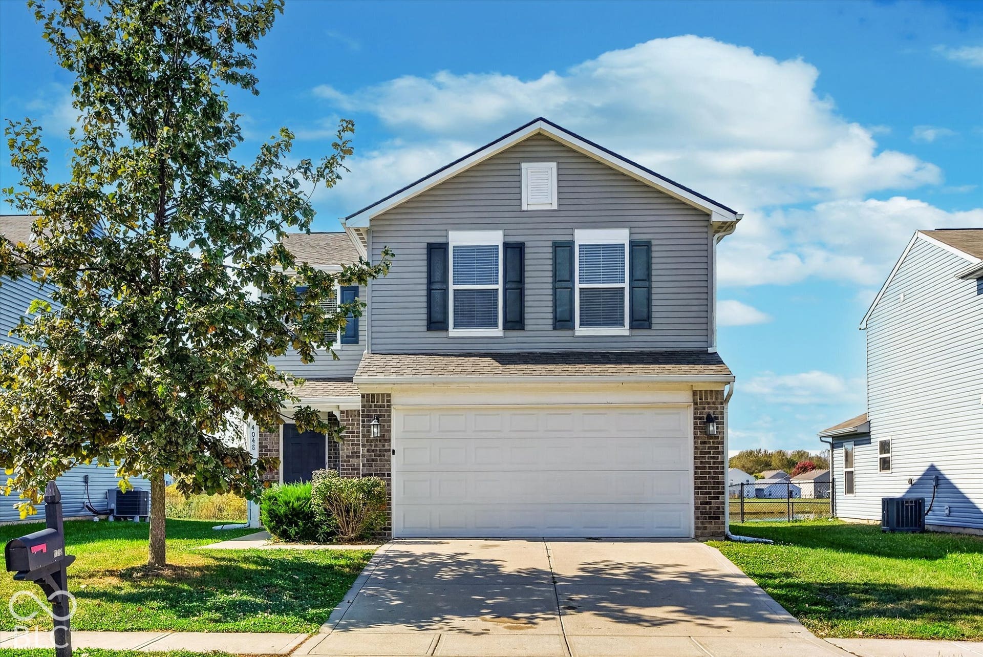 Two-story home featuring and attached garage and paved driveway