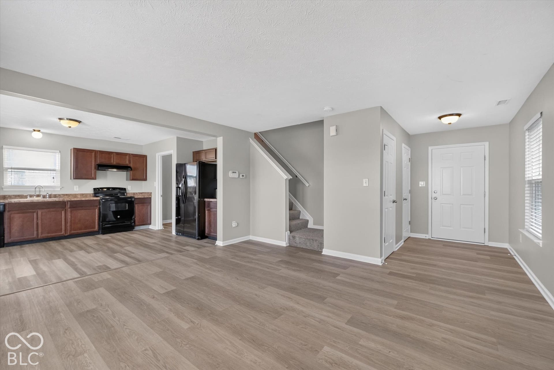 Spacious, open-concept living room with newer LVP flooring and neutral wall color