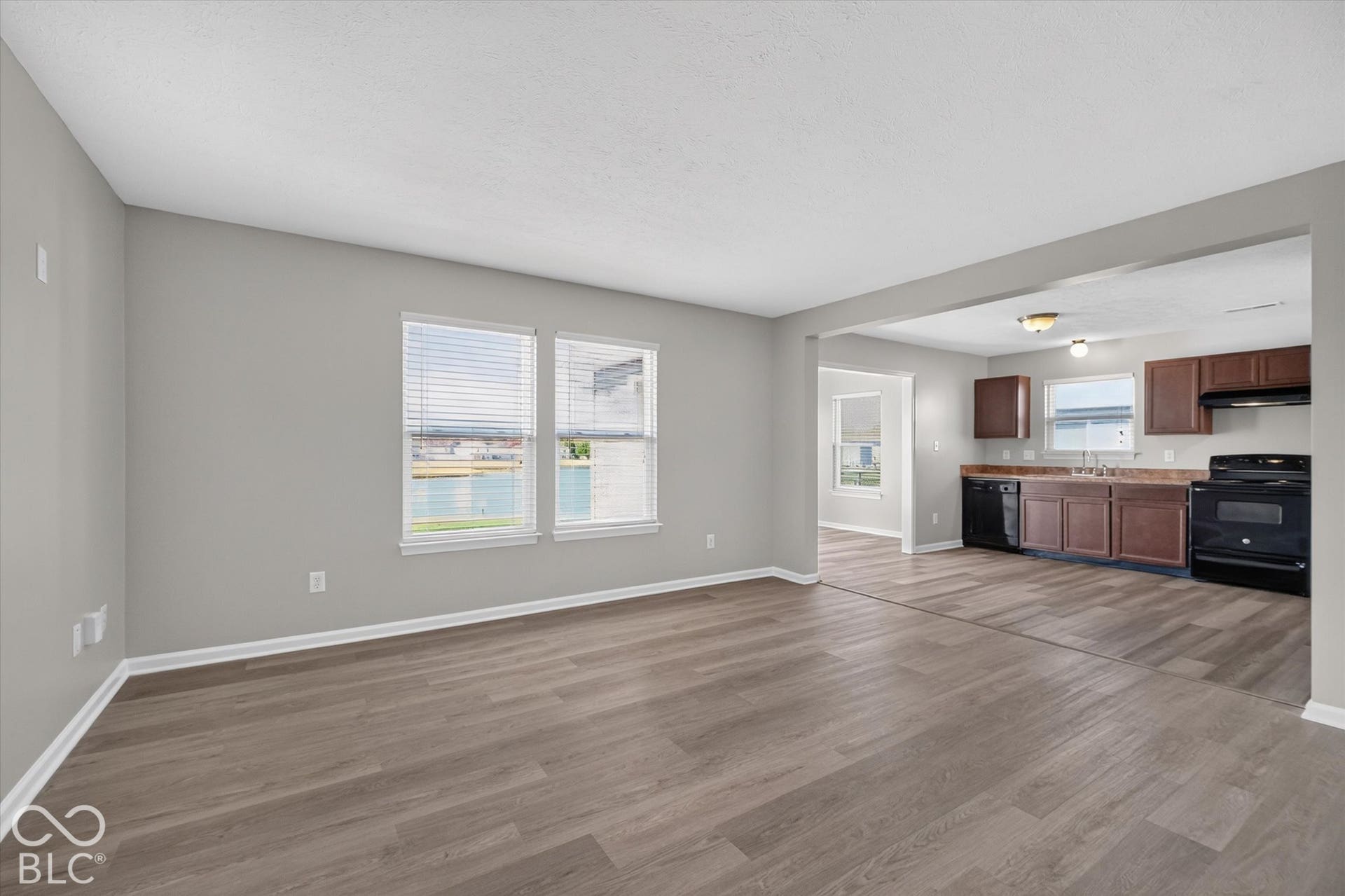 Spacious, open concept living room with newer LVP flooring and neutral wall color