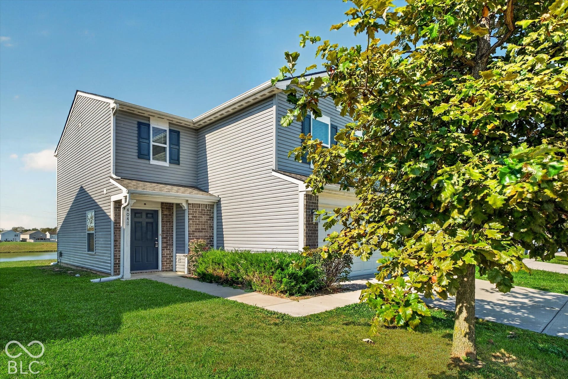 Two-story home featuring and attached garage and paved driveway