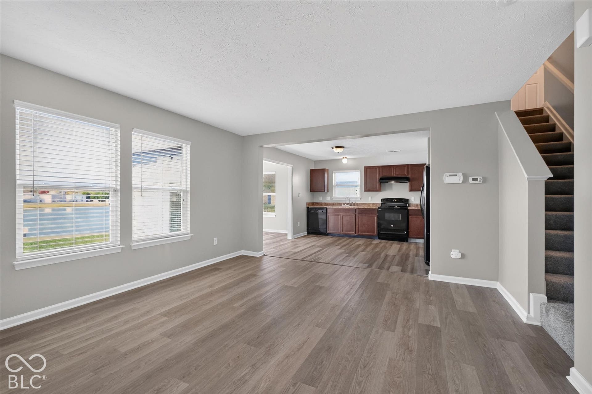 Spacious, open-concept living room with newer LVP flooring and neutral wall color