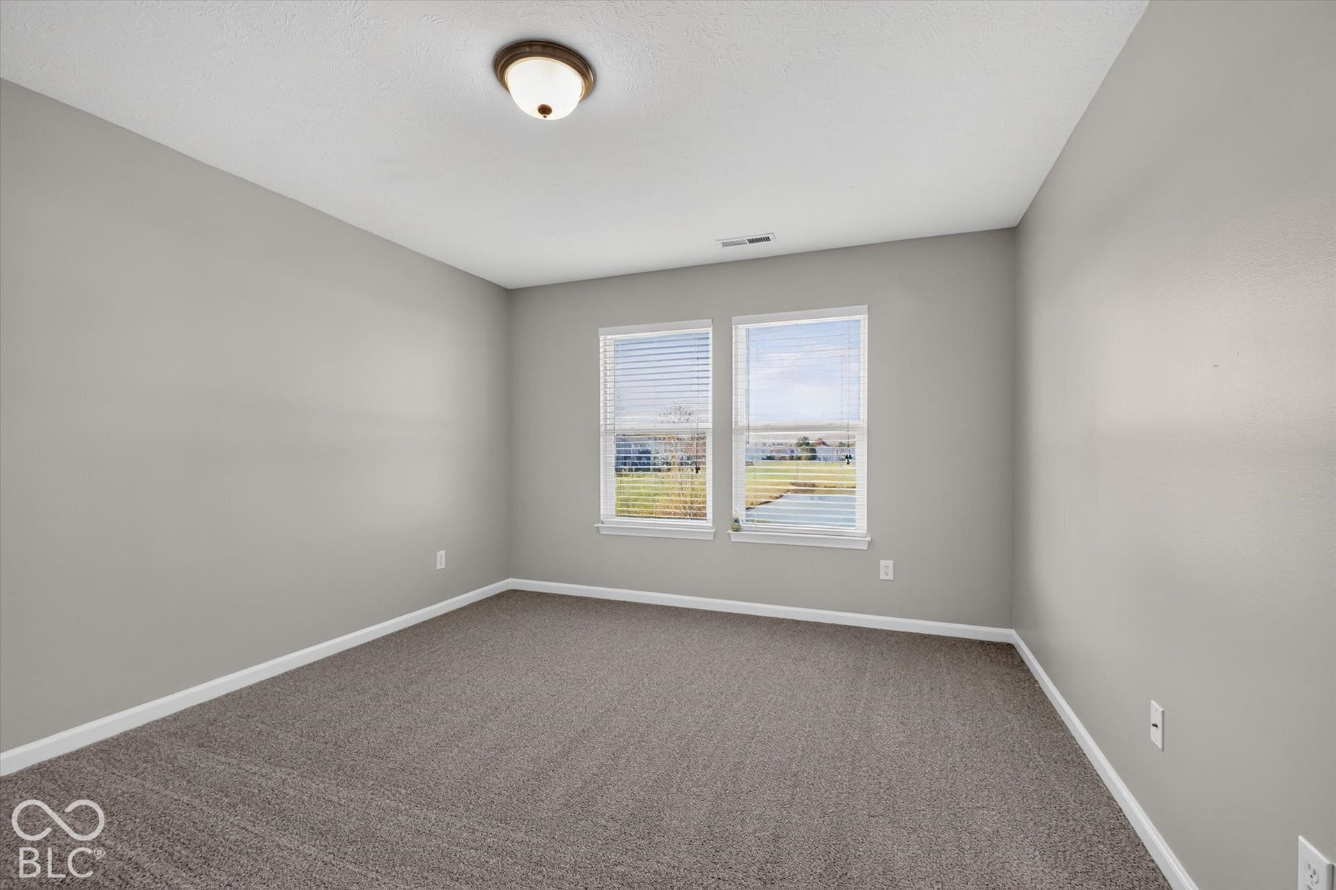 Spacious primary bedroom with new carpet and neutral wall color
