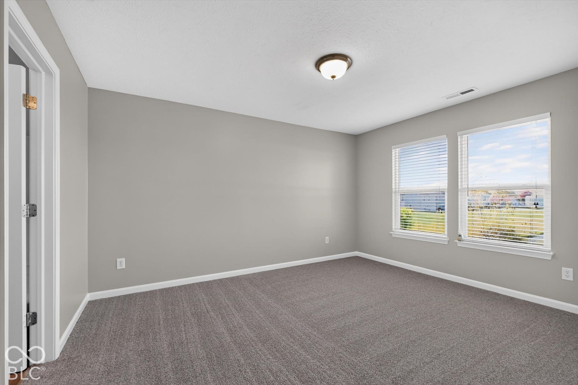 Spacious primary bedroom with new carpet and neutral wall color