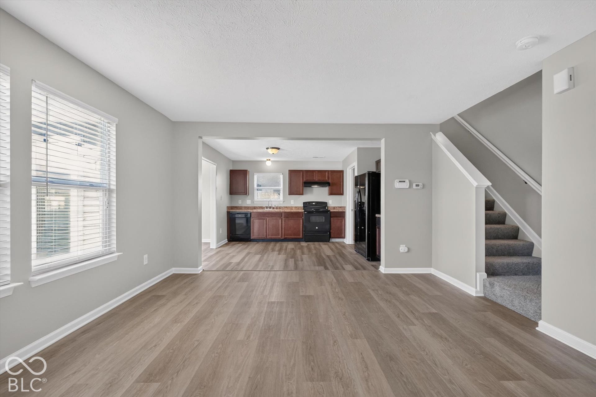 Spacious, open-concept living room with newer LVP flooring and neutral wall color
