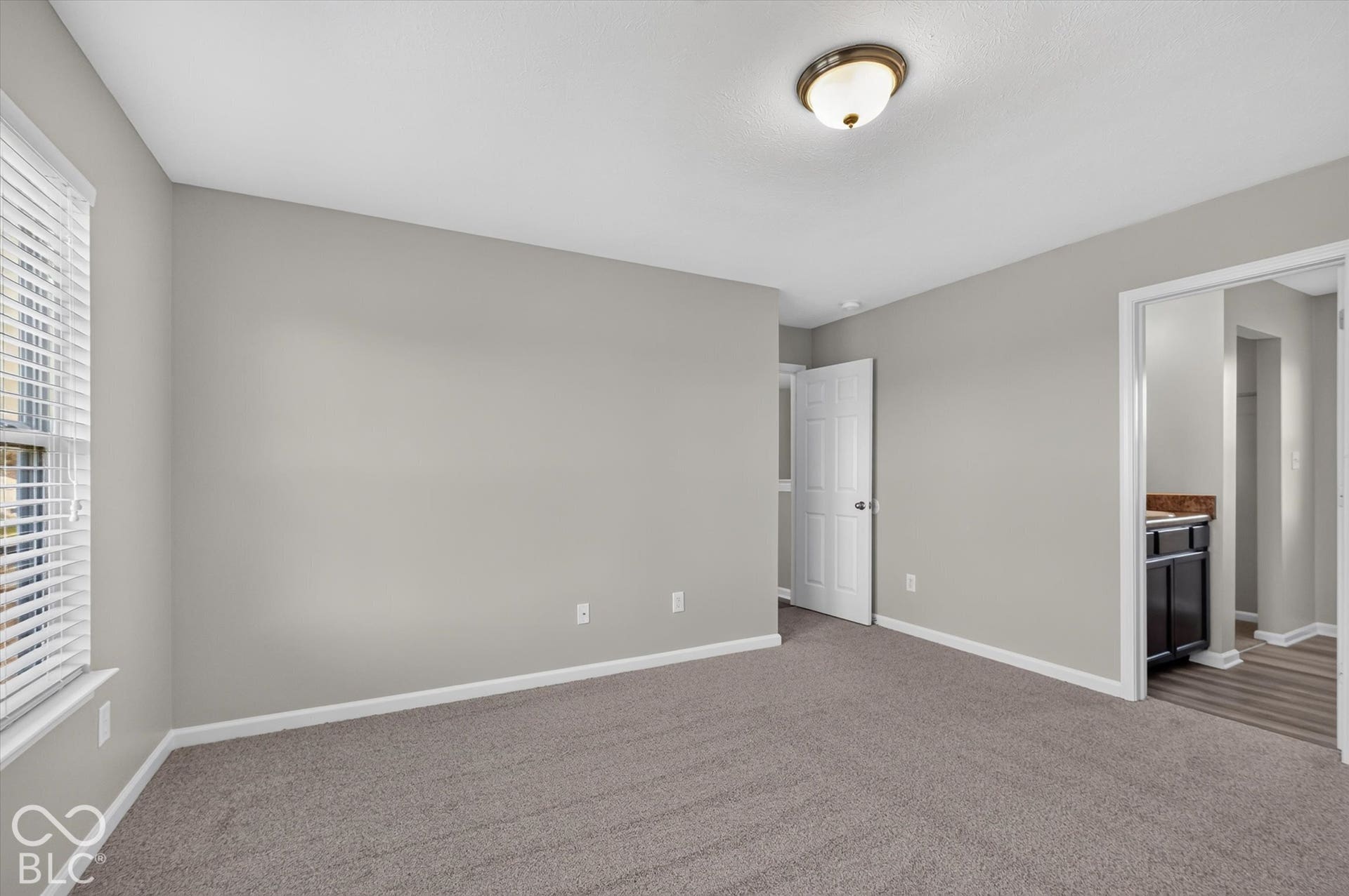 Spacious primary bedroom with new carpet and neutral wall color