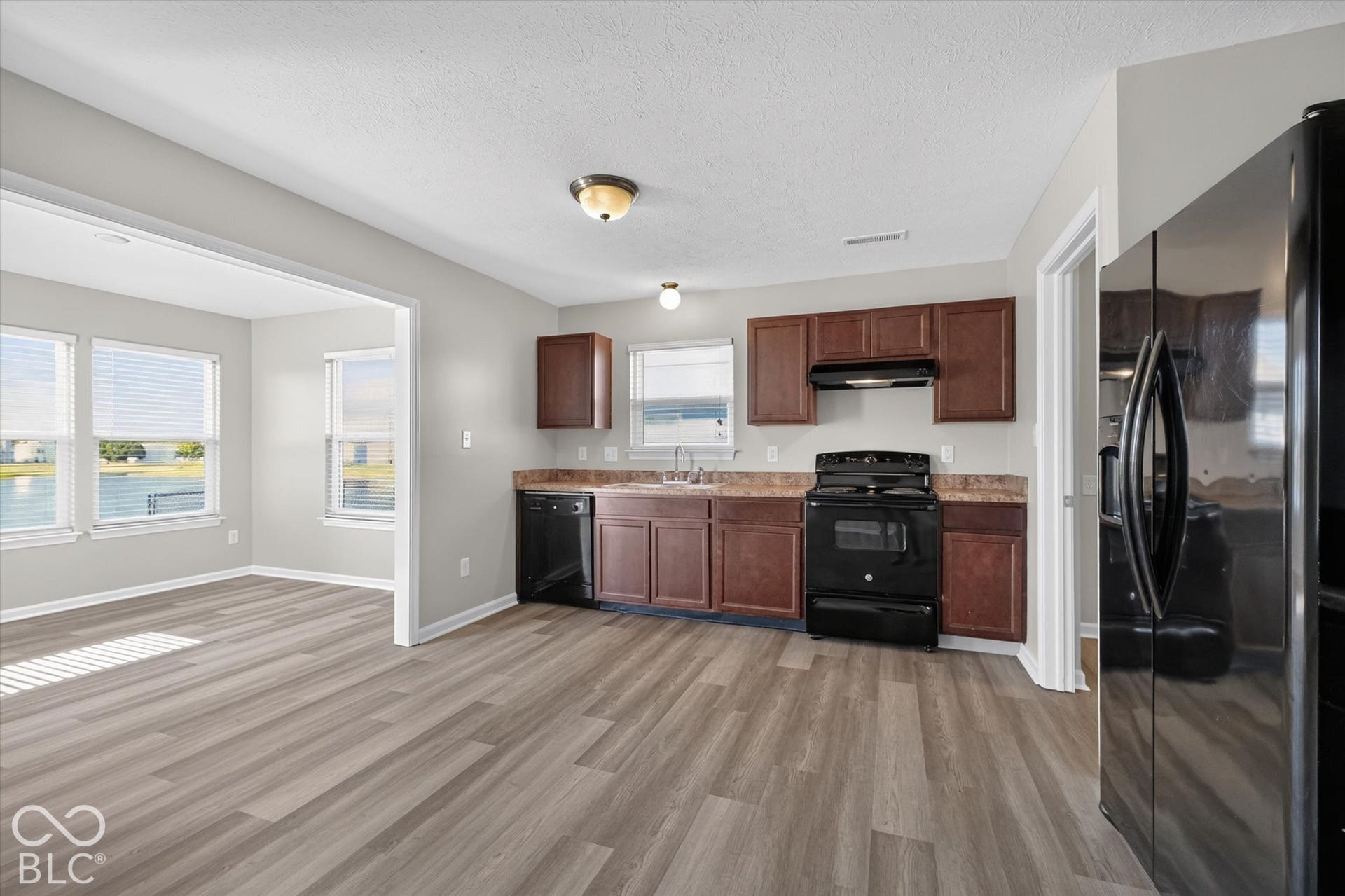 Kitchen featuring newer LVP flooring and black appliances