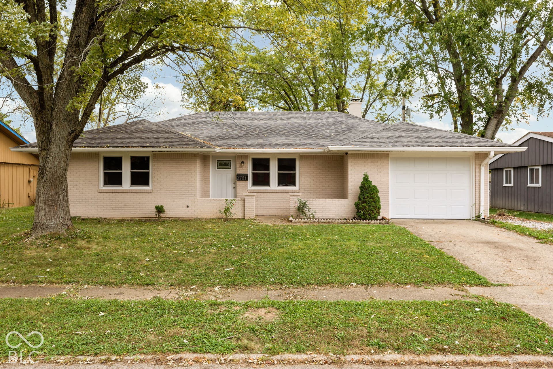 3721 Ireland Drive, Indianapolis, IN 46235 Single-story brick exterior featuring a hip roof, attached garage, covered entryway, and mature trees