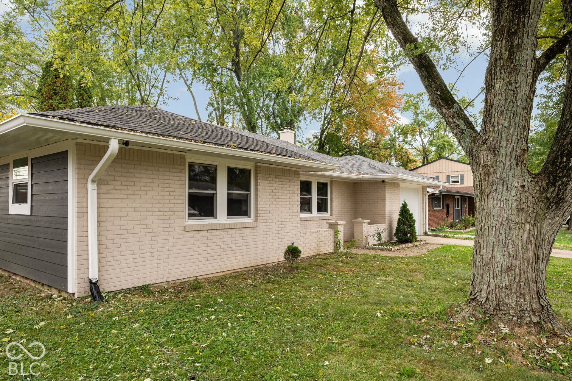3721 Ireland Drive, Indianapolis, IN 46235 Single-story exterior featuring light-toned brick masonry, horizontal siding accents, an attached garage, and a low-pitch roof