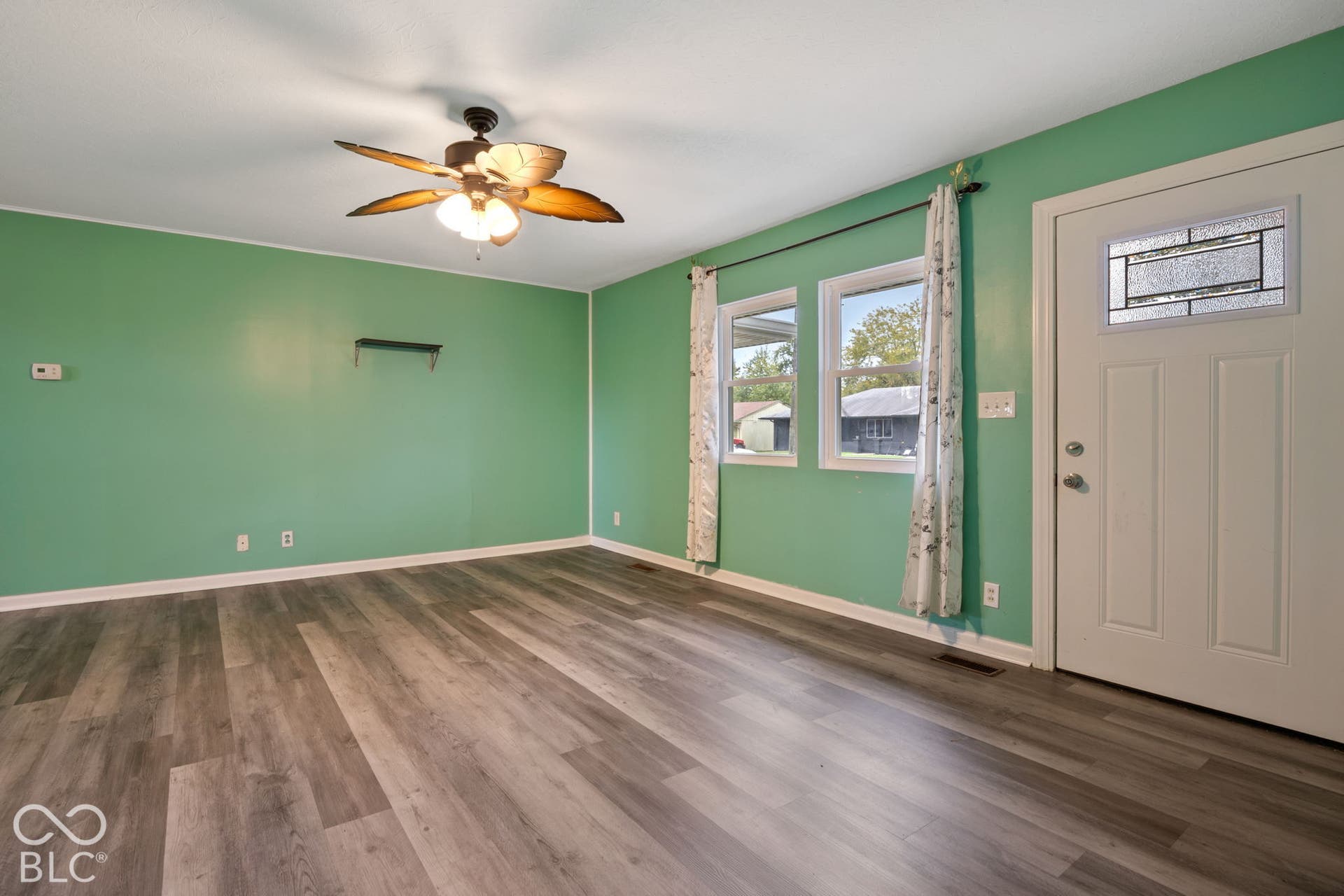 3721 Ireland Drive, Indianapolis, IN 46235 Wood-finish flooring, ceiling fan with integrated lighting, dual-pane windows, and white exterior door with glass inlay