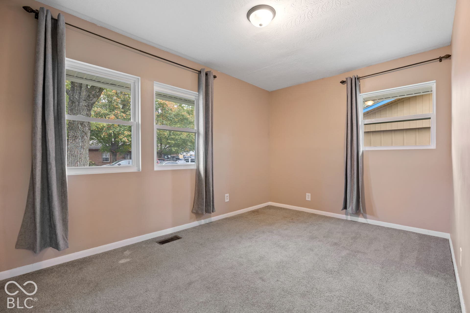 3721 Ireland Drive, Indianapolis, IN 46235 Room featuring neutral wall paint, wall-to-wall carpeting, and three double-pane windows with hardware
