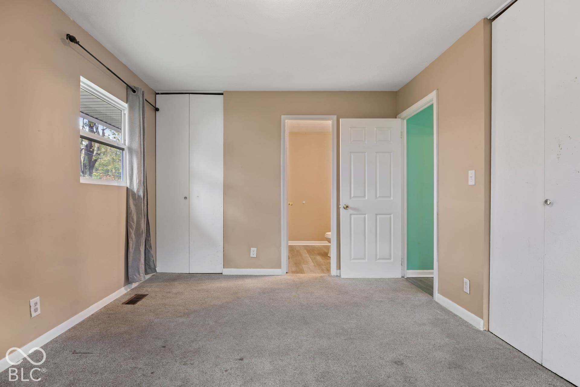 3721 Ireland Drive, Indianapolis, IN 46235 Neutral-toned walls, neutral carpeting, dual white bi-fold closets, and a white six-panel interior door
