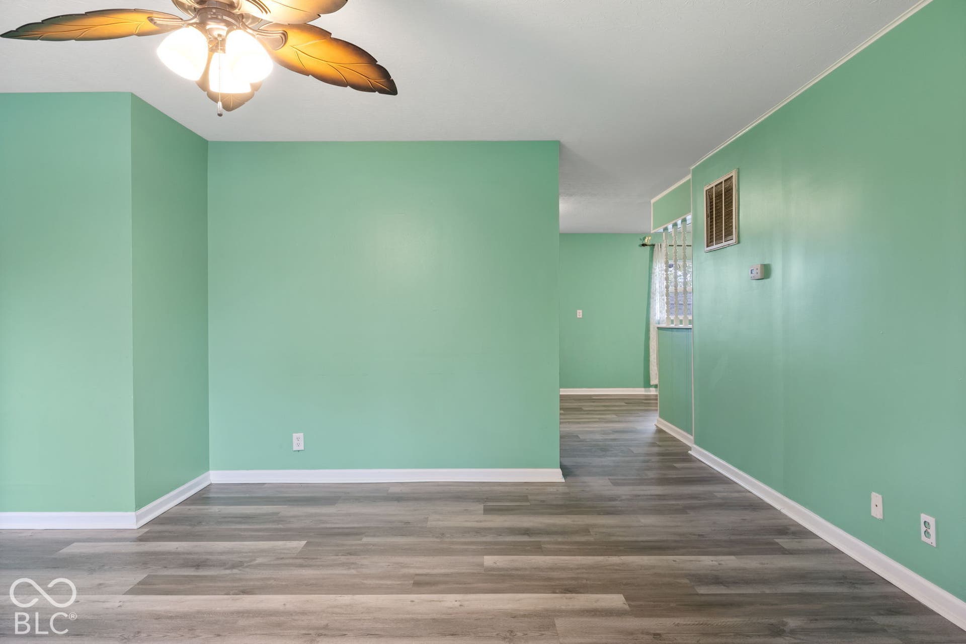 3721 Ireland Drive, Indianapolis, IN 46235 Interior space featuring wood-finish flooring, a ceiling-mounted light fixture with palm leaf detailing, and interior wall pass-through