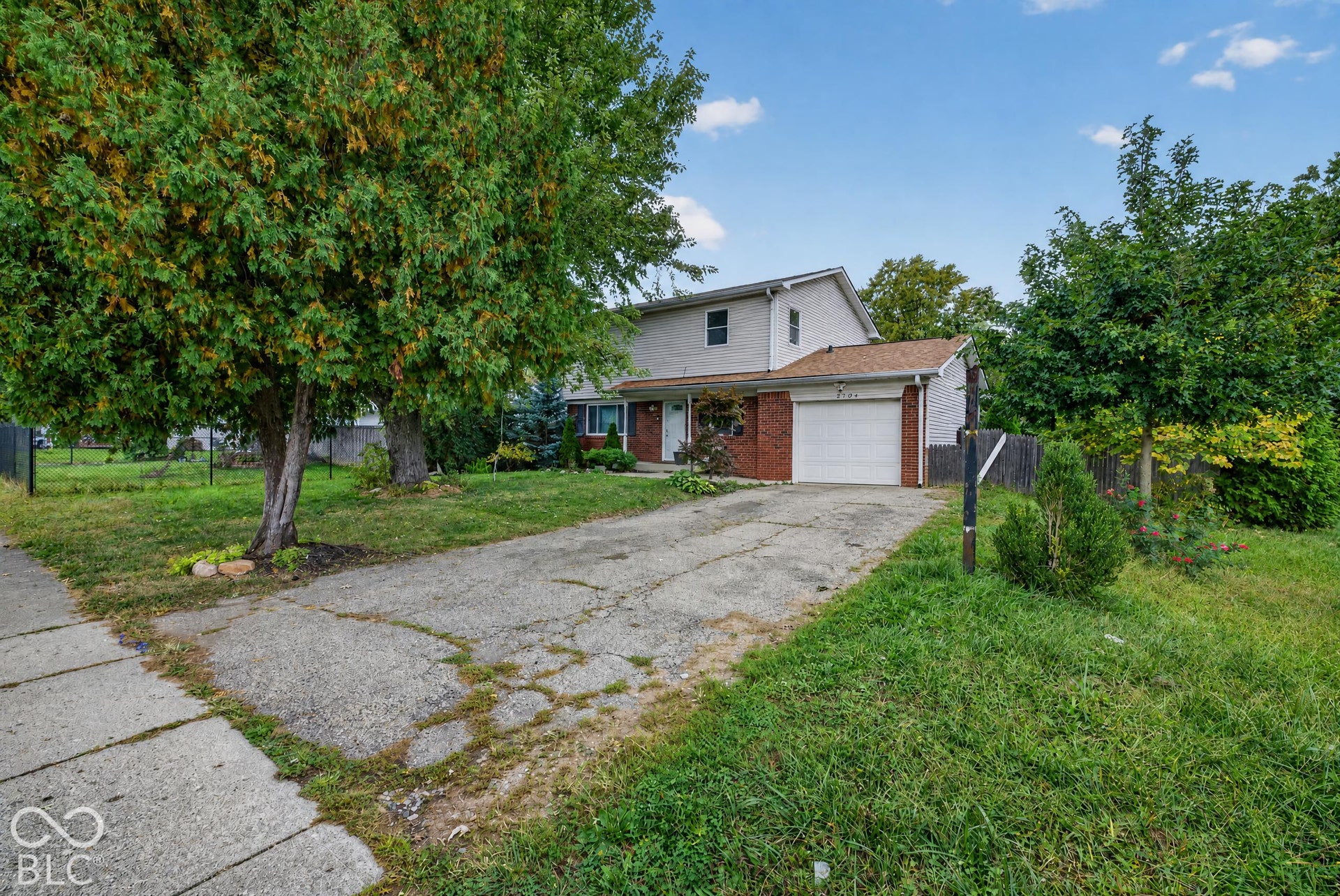 Virtually Altered - Two-story exterior featuring a brick and horizontal siding facade, attached single-car garage, and concrete driveway