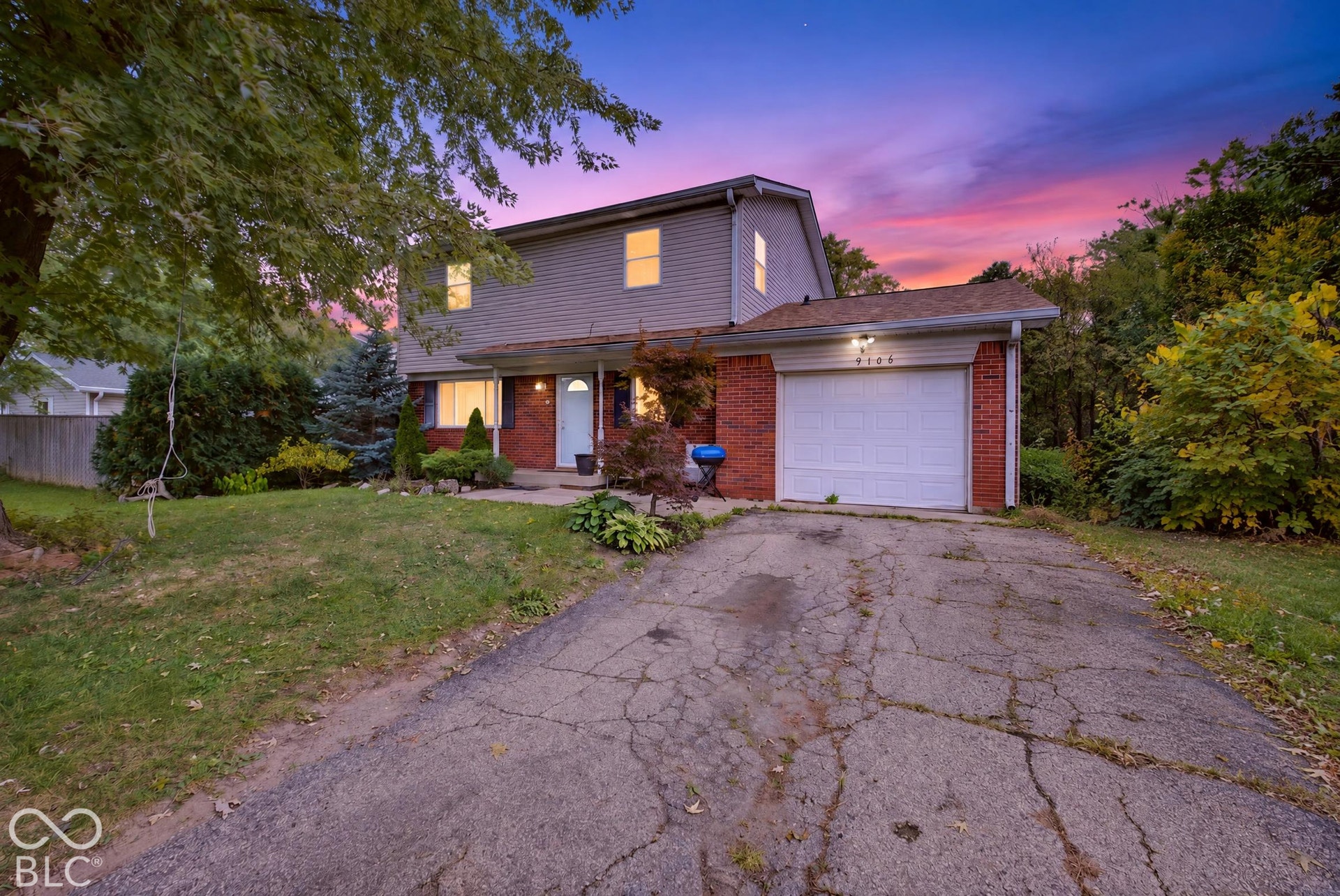 Virtually Altered - Two-story exterior featuring a brick and siding facade, attached single-car garage, and asphalt driveway