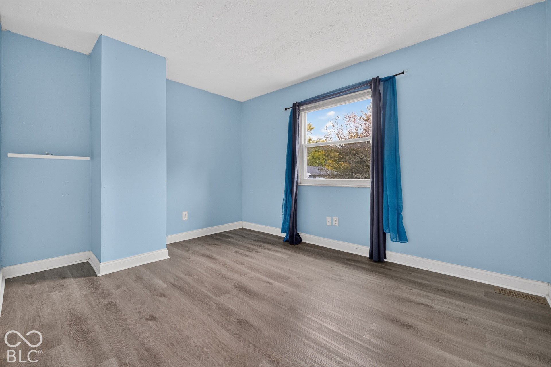 Room featuring wood-finish flooring and a single-pane window