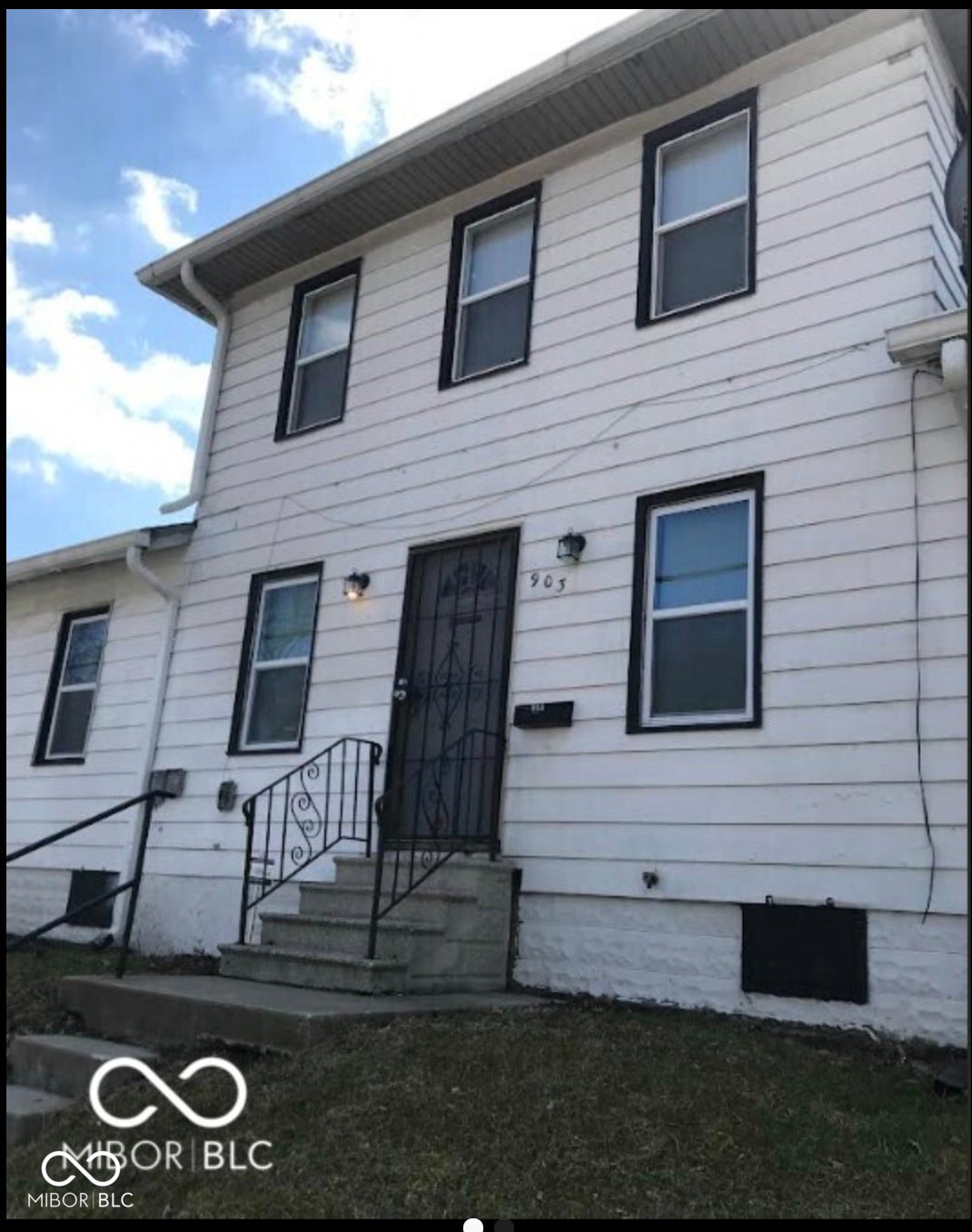 Two-story exterior with white siding and contrasting dark window trim