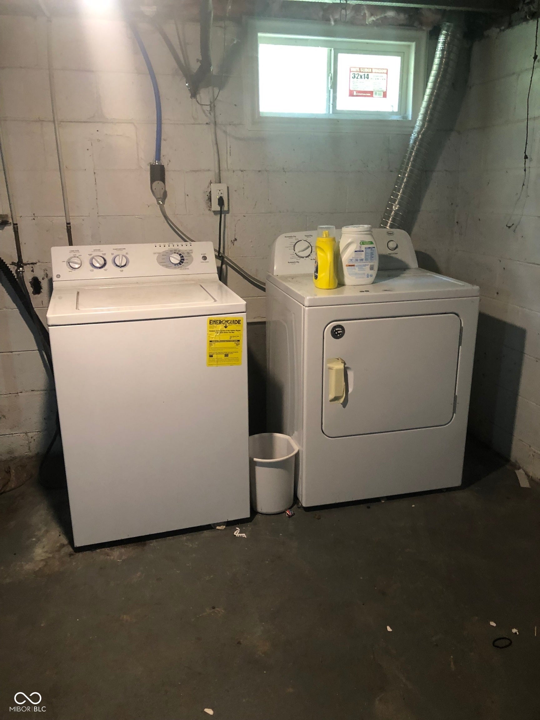 Laundry area featuring a top-load washing machine, front-load dryer, and a window