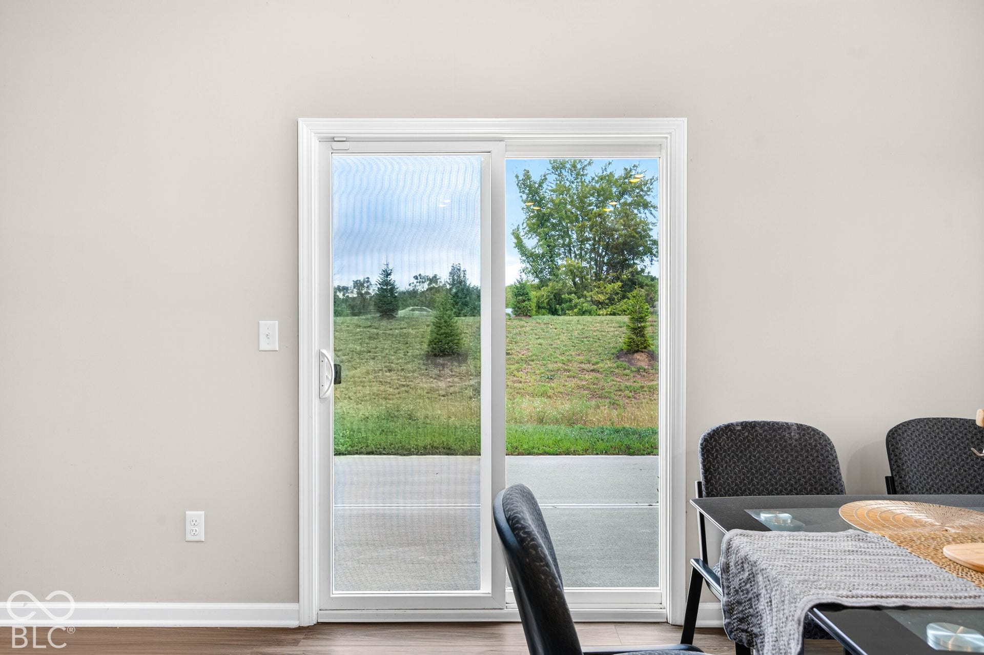 Sliding glass door featuring a white frame and wood-finish flooring