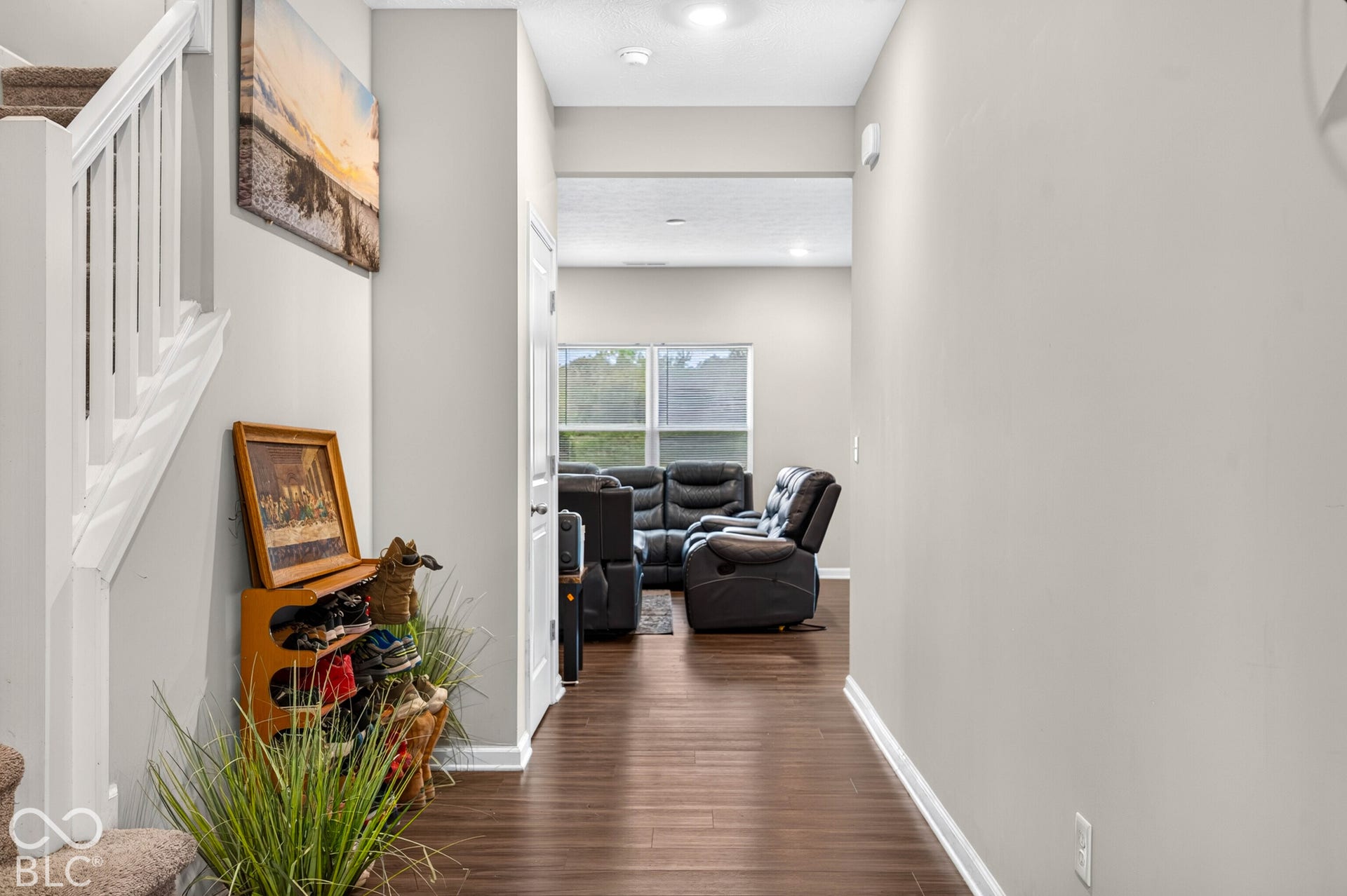 Foyer featuring wood-finish flooring, white staircase railing, and recessed ceiling lighting