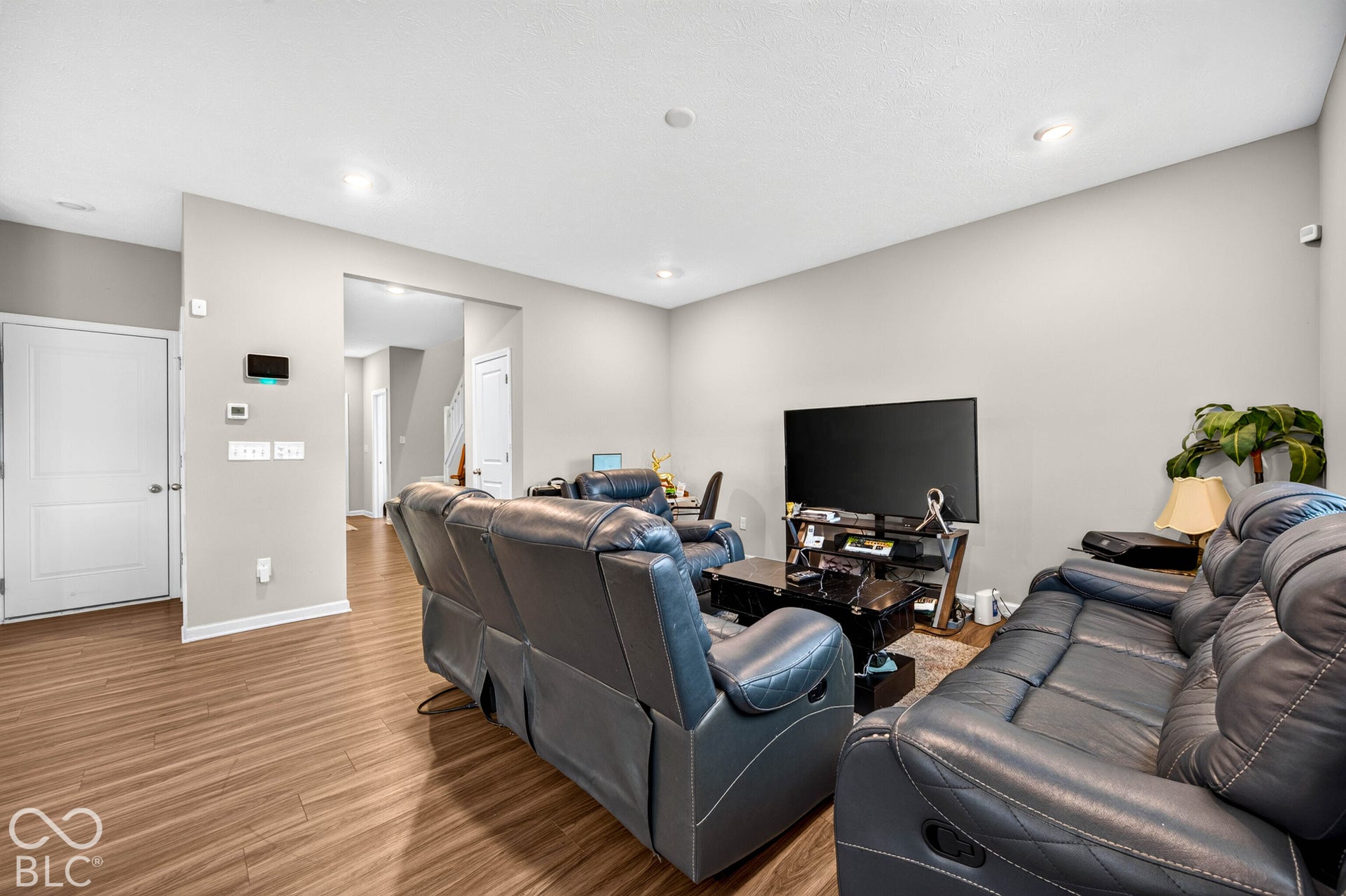 Open-concept living space featuring wood-finish flooring and recessed lighting