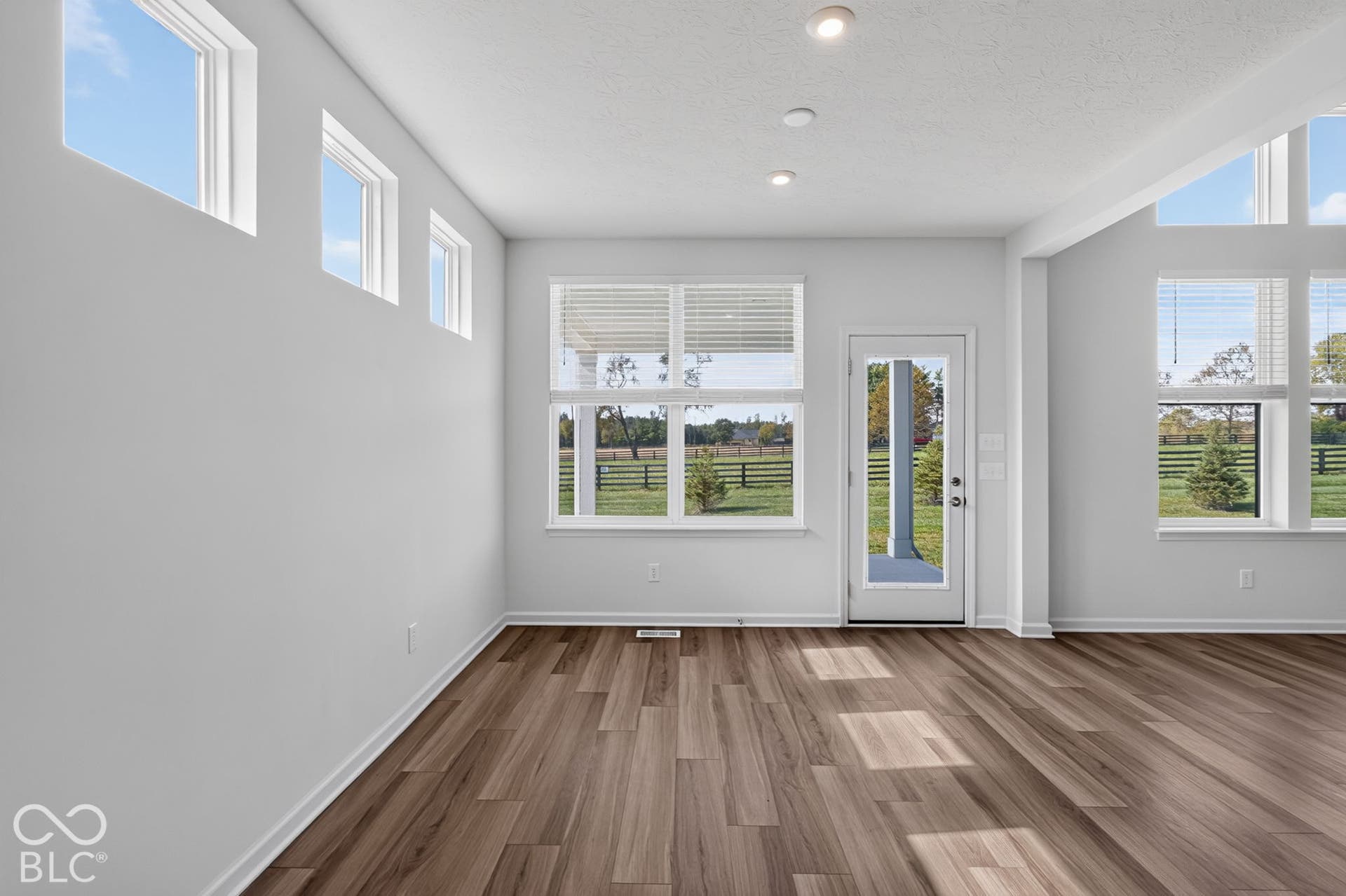 Vaulted ceilings, wood-finish flooring, multi-pane windows, and a glass-paneled exterior door